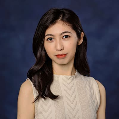A headshot of Sixian Liu. She is smiling and standing against a blue background.
